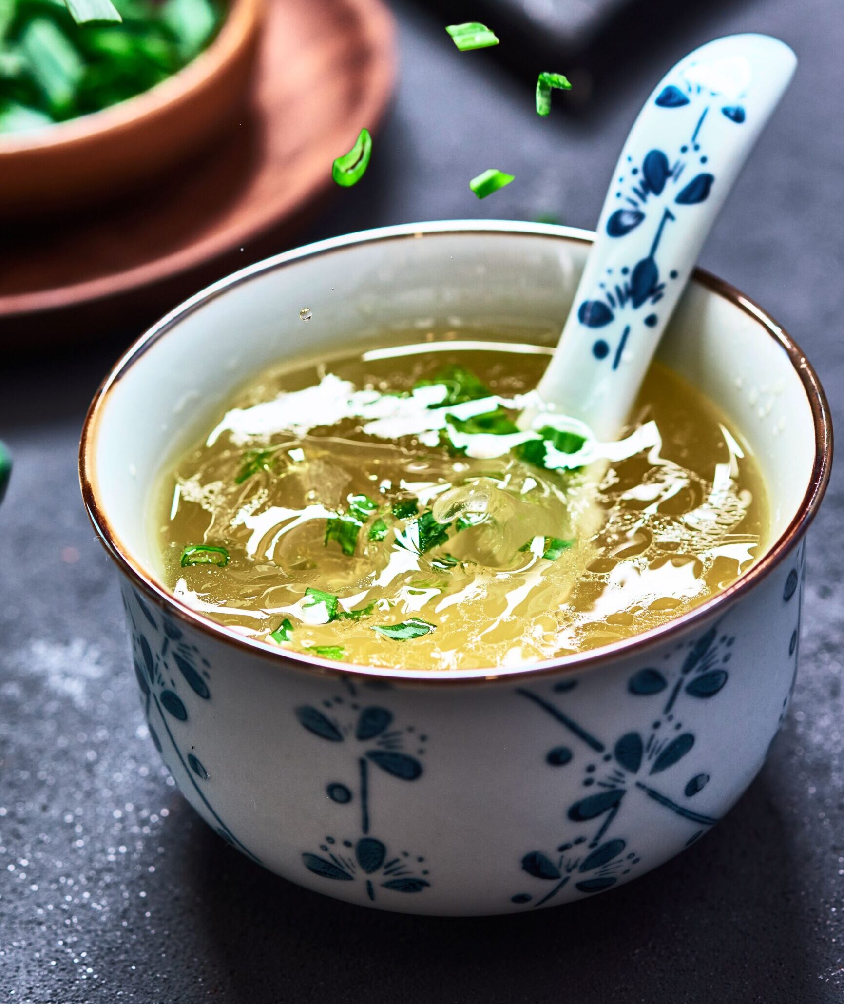 Warm, comforting homemade chicken soup garnished with fresh herbs in a ceramic bowl.