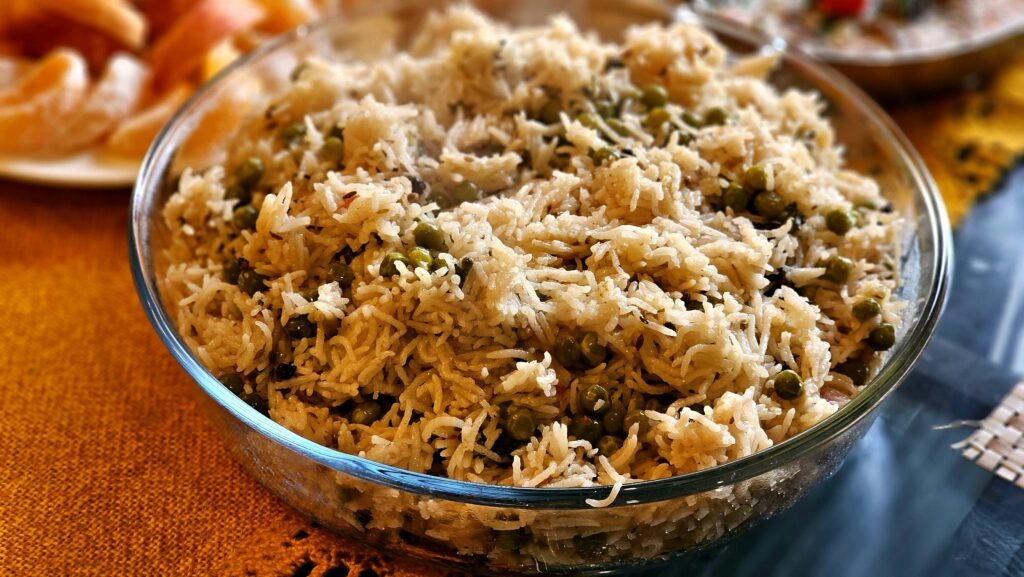Mouthwatering pea pulao served hot in a transparent glass bowl, perfect for any meal.