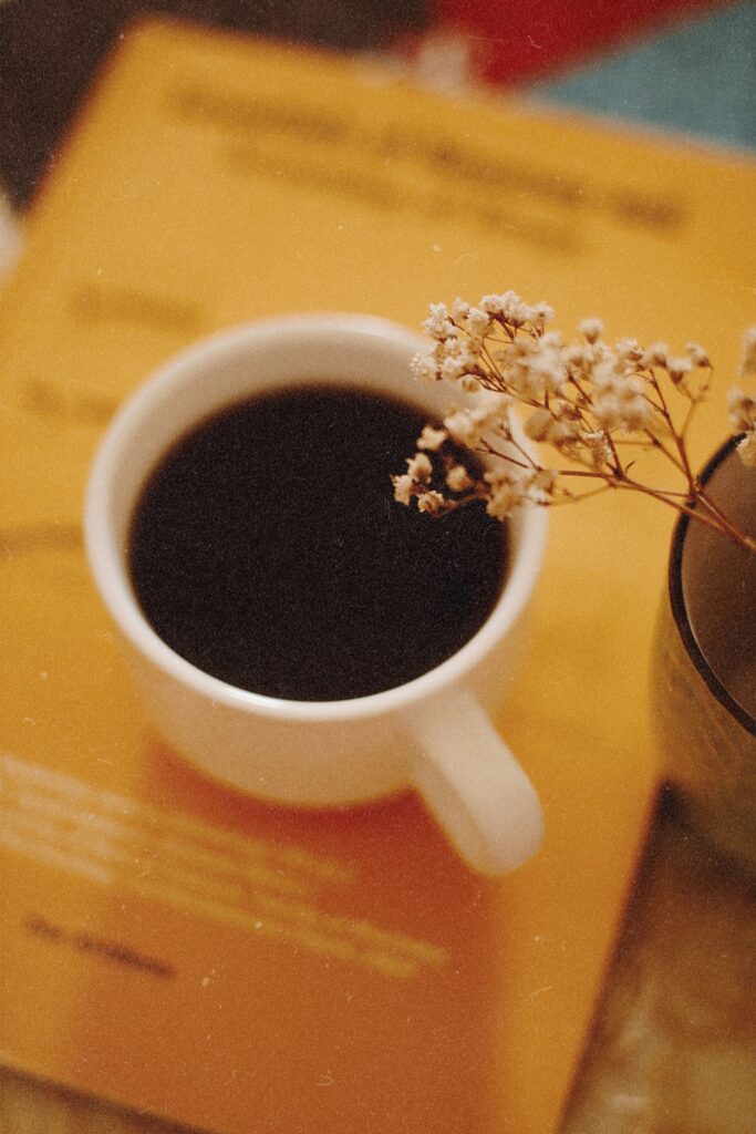 Warm ambiance with a coffee mug and flowers on a textured surface.