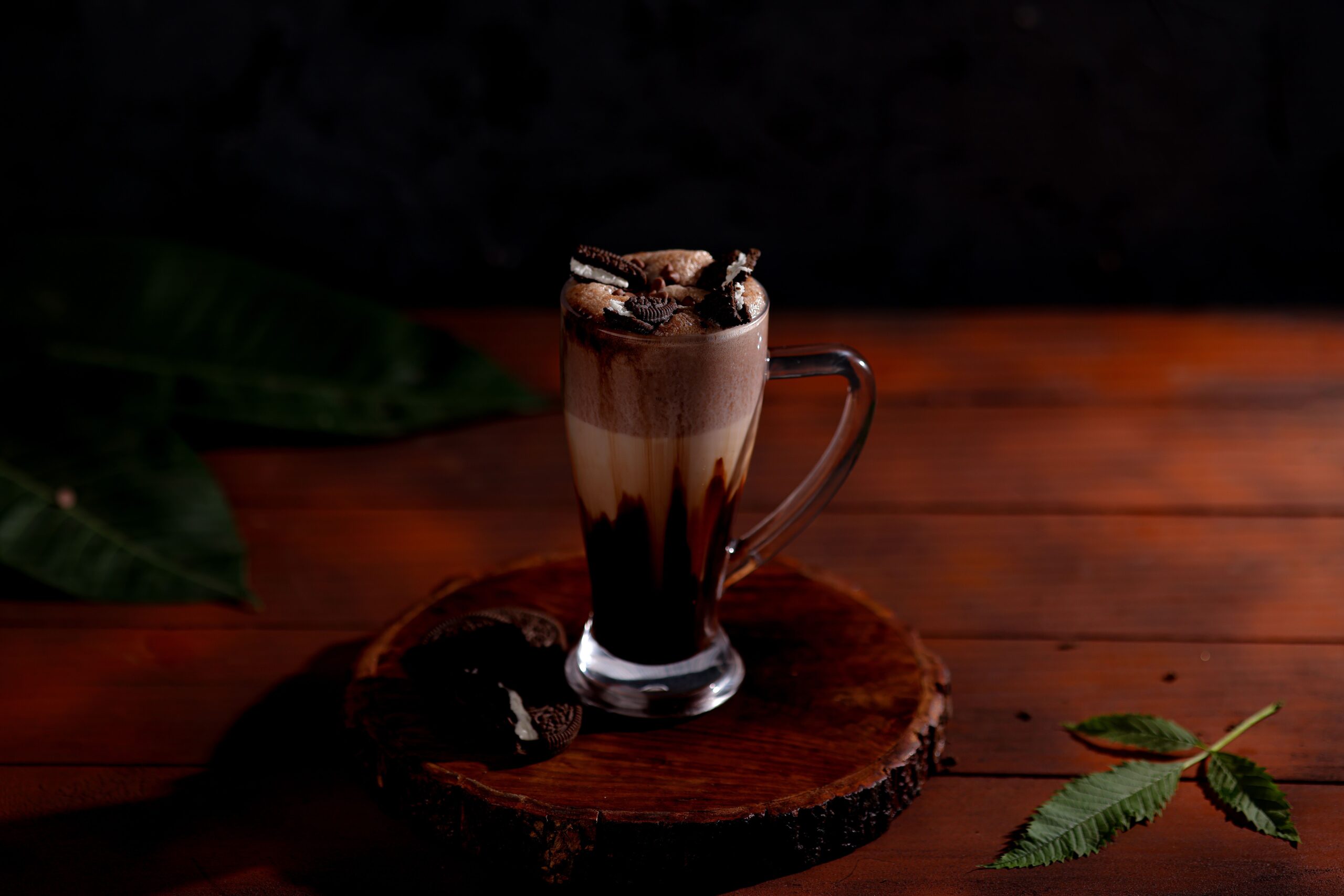 Rich chocolate milkshake topped with cookies on a wooden slab, inviting indulgence.