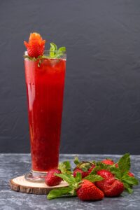 Vibrant strawberry mocktail garnished with mint leaves and fresh strawberries.