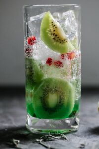 Close-up of a refreshing kiwi and pomegranate infused sparkling drink in a glass.
